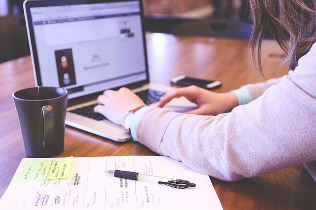 Woman sitting at desk with laptop and coffee mug. What are your weaknesses?